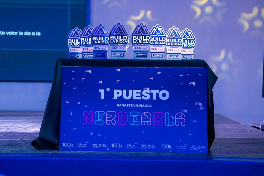 The #BuildLaRioja trophies next to the first place sign: a trip to Nerdearla