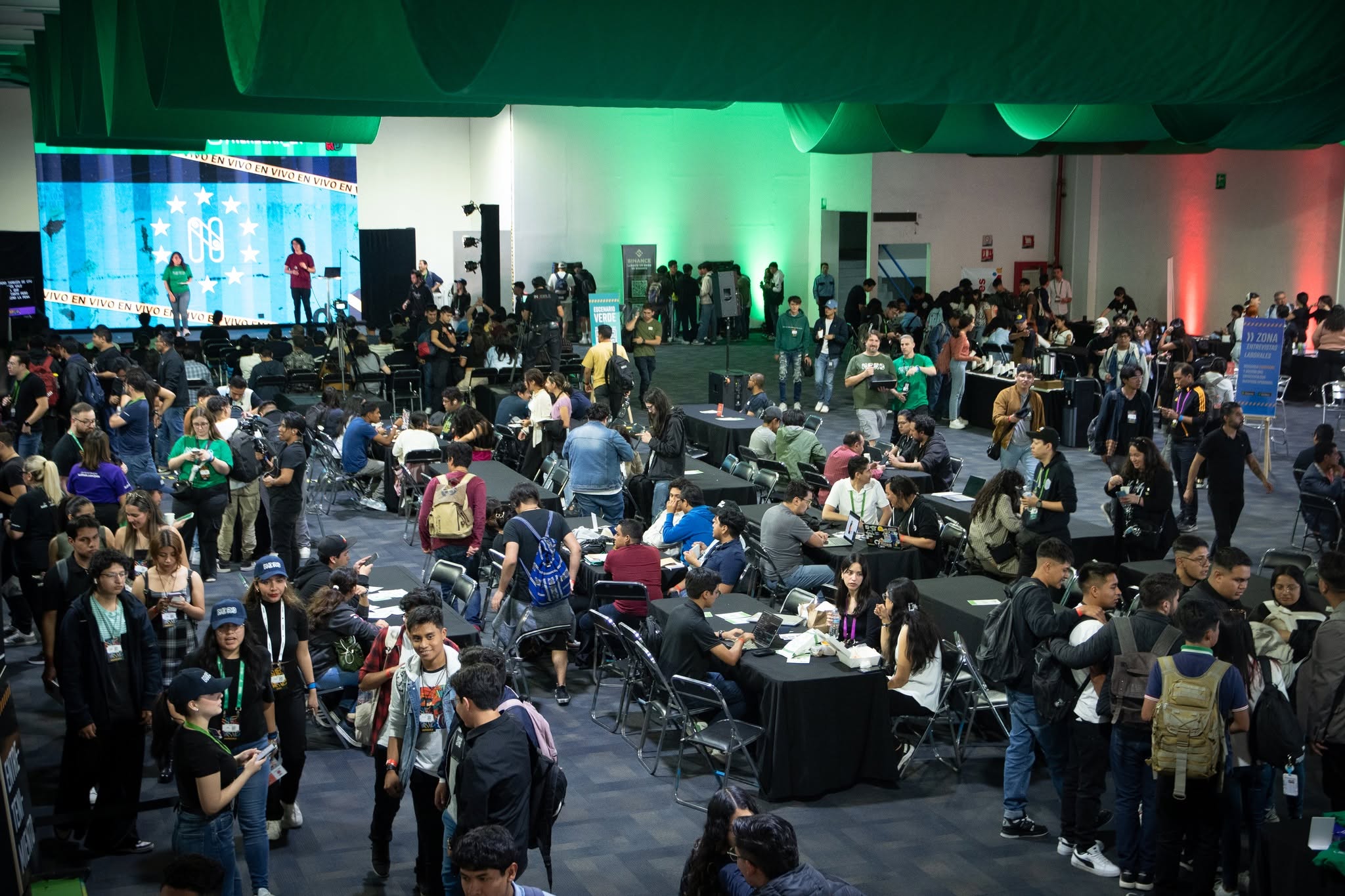 The Expo Reforma hall full of people, with the cowork tables taken and the main stage in the background