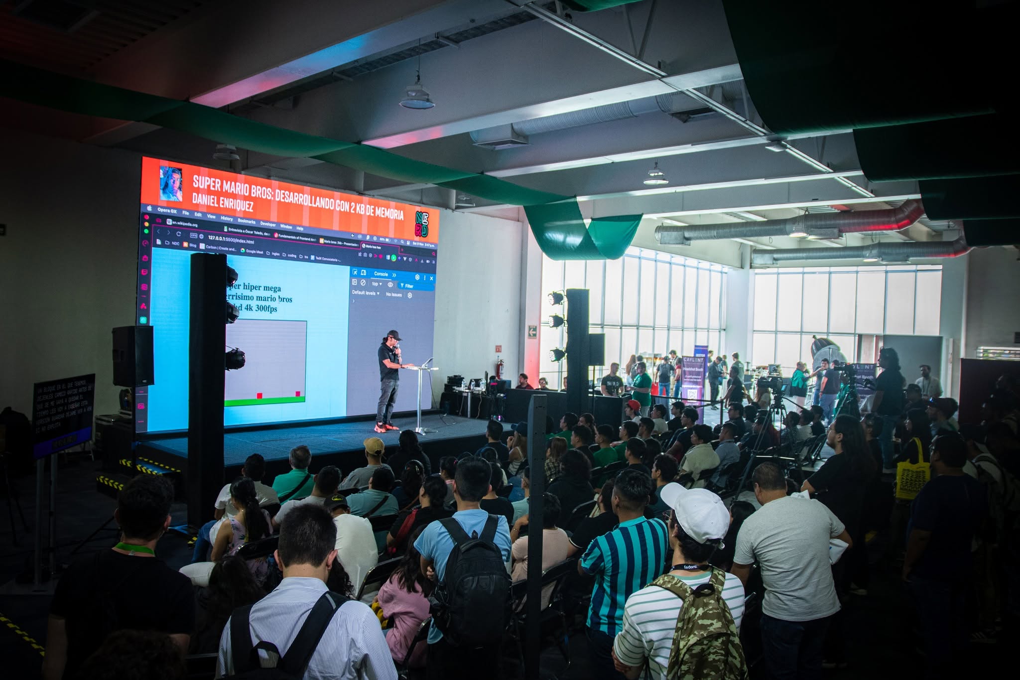 A full room during a talk about Super Mario Bros, seen from the back